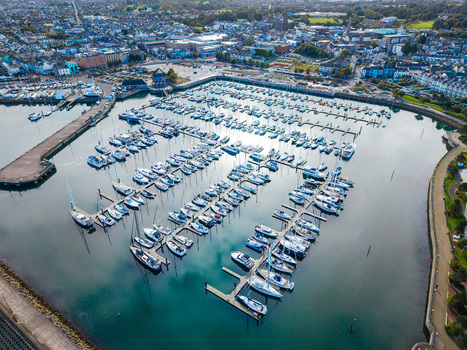 Aerial view of Bangor Harbour and Town with numerous yachts and boats moored in the marina surrounded by coastal buildings and urban infrastructure in Bangor Northern Ireland United Kingdom.