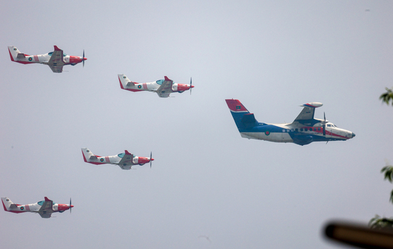 Dhaka Bangladesh 25 March 2026 View of a squadron of aircraft with red and white wings soaring high above in the clear sky a display of precision and power.