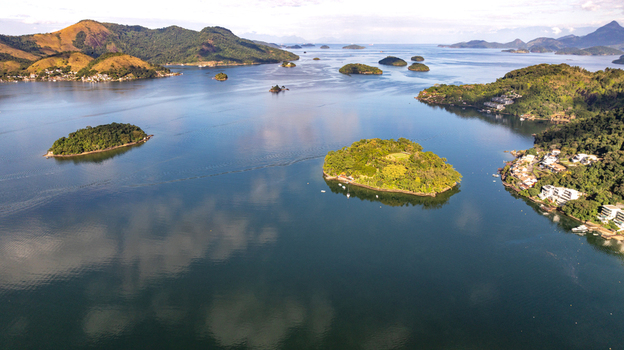 Aerial view of islands and coastal landscape with lush vegetation calm blue waters and scattered residential buildings along the shoreline Angra dos Reis Rio de Janeiro Brazil.