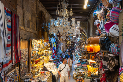 Cairo Egypt 20 April 2026 View of Khan el Khalili bazaar with people walking past shops filled with traditional lamps textiles and leather goods under hanging chandeliers. Cairo Egypt 20 April 2026 View of Khan el Khalili bazaar with people walking past shops filled with traditional lamps textiles and leather goods under hanging chandeliers.