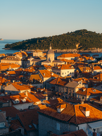 View of the historic rooftops and the Cathedral dome in the Old Town with Lokrum Island in the distance Dubrovnik Dubrovnik Neretva County Croatia. View of the historic rooftops and the Cathedral dome in the Old Town with Lokrum Island in the distance Dubrovnik Dubrovnik Neretva County Croatia.