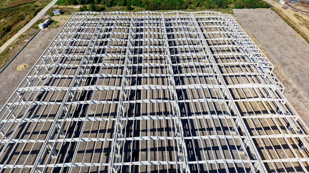 Aerial view of the concrete frame structure of a large industrial hall under construction on a gravel site in Kovin Vojvodina Serbia. Aerial view of the concrete frame structure of a large industrial hall under construction on a gravel site in Kovin Vojvodina Serbia.