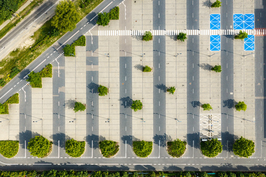 Aerial view of a large parking lot with marked spaces green trees and blue handicap parking spots in Warsaw Masovian Voivodeship Poland. Aerial view of a large parking lot with marked spaces green trees and blue handicap parking spots in Warsaw Masovian Voivodeship Poland.