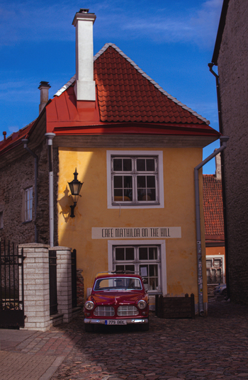 Tallinn Estonia 08 April 2026 View of the historic Cafe Mathilda on the Hill building with a vintage red car parked on a cobblestone street in the Vanalinn district. Tallinn Estonia 08 April 2026 View of the historic Cafe Mathilda on the Hill building with a vintage red car parked on a cobblestone street in the Vanalinn district.