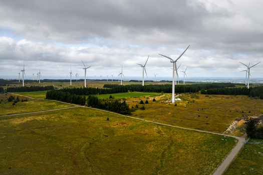Aerial view of Hog Jaeren wind farm with numerous white wind turbines standing in a vast green landscape under a cloudy sky in Ha Municipality Rogaland Norway. Aerial view of Hog Jaeren wind farm with numerous white wind turbines standing in a vast green landscape under a cloudy sky in Ha Municipality Rogaland Norway.