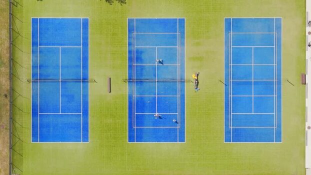 Aerial view of blue tennis courts with players Czechia. Aerial view of blue tennis courts with players Czechia.