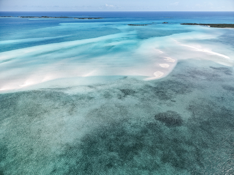 Aerial view of the Man O War Cay Sandbar featuring turquoise waters and white sandbars surrounded by coral reefs in Rolletown Exuma The Bahamas. Aerial view of the Man O War Cay Sandbar featuring turquoise waters and white sandbars surrounded by coral reefs in Rolletown Exuma The Bahamas.