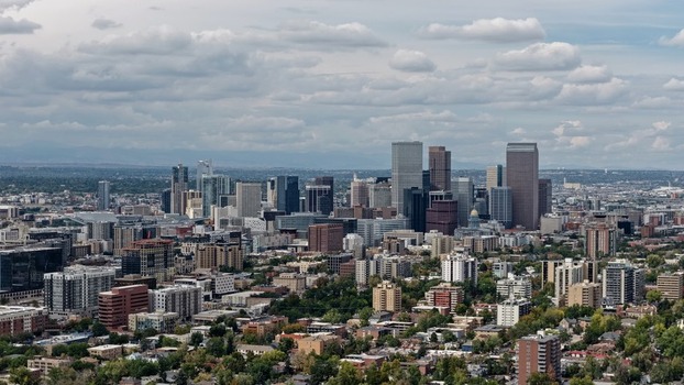 Aerial view of the Denver skyline featuring the Cherry Creek area with dense urban development modern skyscrapers and lush green trees in Denver Colorado United States. Aerial view of the Denver skyline featuring the Cherry Creek area with dense urban development modern skyscrapers and lush green trees in Denver Colorado United States.
