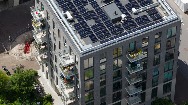Aerial view of a modern apartment building on Cruquiusweg featuring rooftop solar panels and balconies in Amsterdam Noord Holland Netherlands.