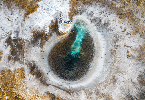Aerial view of Hveravellir geothermal hot spring with vibrant turquoise water and textured mineral crust in Hunabyggd Iceland. Aerial view of Hveravellir geothermal hot spring with vibrant turquoise water and textured mineral crust in Hunabyggd Iceland.