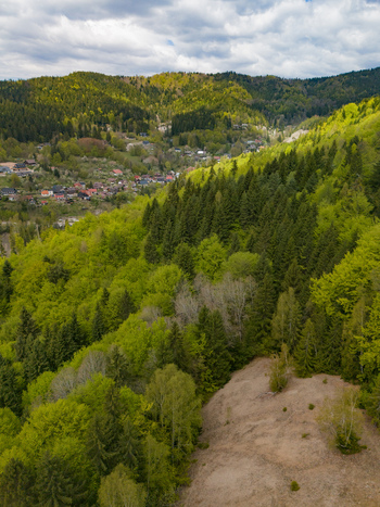 Aerial view of Maria Mine Spoil Heap surrounded by lush green forests and the historic village under a cloudy sky Spania Dolina Banska Bystrica Regio Slovakia. Aerial view of Maria Mine Spoil Heap surrounded by lush green forests and the historic village under a cloudy sky Spania Dolina Banska Bystrica Regio Slovakia.