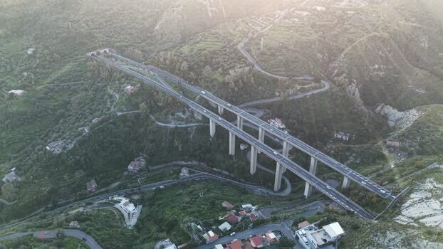 Aerial view of a highway viaduct in a lush valley Italy.