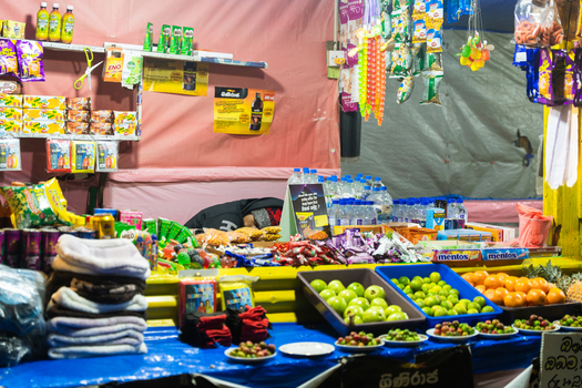 Ratnapura Sri Lanka 22 February 2026 View of a small roadside stall selling snacks bottled water and fresh fruits along the pilgrimage path to Adam s Peak at night.