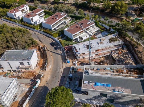 Aerial view of the Quinta da Marinha residential construction site with modern villas ongoing building works a tall crane and pine trees in Cascais Lisbon Portugal. Aerial view of the Quinta da Marinha residential construction site with modern villas ongoing building works a tall crane and pine trees in Cascais Lisbon Portugal.