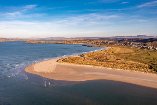 Aerial view of Sheephaven Bay featuring a sandy beach coastal dunes and rolling hills under a clear blue sky in Dunfanaghy County Donegal Ireland. Aerial view of Sheephaven Bay featuring a sandy beach coastal dunes and rolling hills under a clear blue sky in Dunfanaghy County Donegal Ireland.