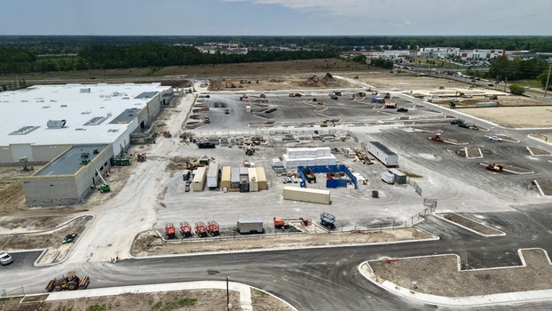 Aerial view of the construction site at Foundry Lane featuring a large warehouse building heavy machinery and shipping containers World Golf Village Florida United States.
