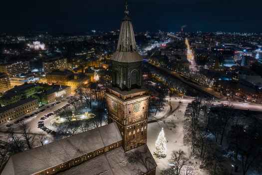 Aerial view of Turku Cathedral illuminated at night during winter with snow covered grounds and a glowing Christmas tree in Turku Varsinais Suomi Finland.