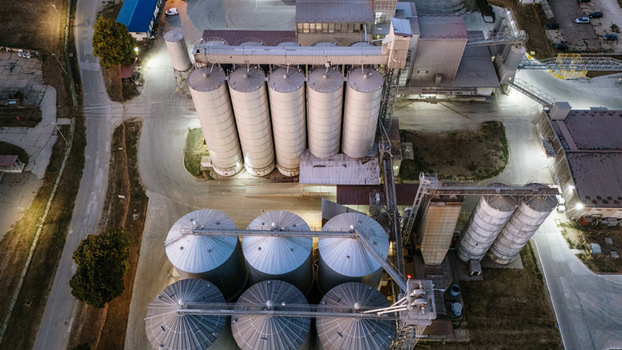 Aerial view of industrial grain silos illuminated at night in the facility grounds in Sremska Mitrovica Vojvodina Serbia. Aerial view of industrial grain silos illuminated at night in the facility grounds in Sremska Mitrovica Vojvodina Serbia.