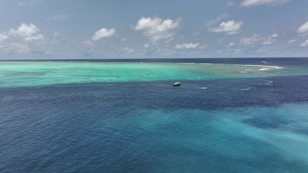 Aerial view of turquoise coral reefs and a boat in the sea Maldives. Aerial view of turquoise coral reefs and a boat in the sea Maldives.