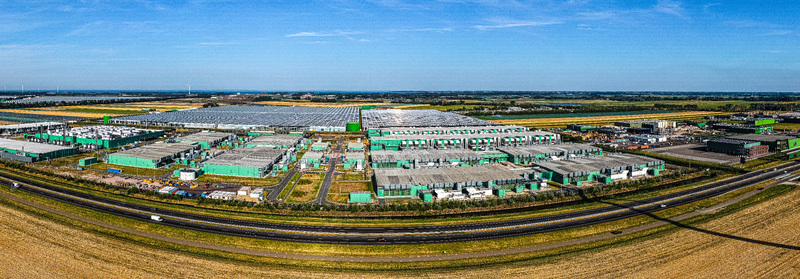 Aerial view of the Agriport A7 greenhouse complex and industrial park with expansive glass rooftops surrounded by agricultural fields and a highway in Middenmeer Noord Holland Netherlands. Aerial view of the Agriport A7 greenhouse complex and industrial park with expansive glass rooftops surrounded by agricultural fields and a highway in Middenmeer Noord Holland Netherlands.