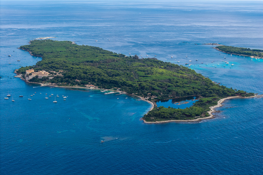 Aerial view of Ile Sainte Marguerite with historic fortifications lush forests and sailboats in the Mediterranean Sea near Cannes Provence Alpes Cote d Azur France. Aerial view of Ile Sainte Marguerite with historic fortifications lush forests and sailboats in the Mediterranean Sea near Cannes Provence Alpes Cote d Azur France.