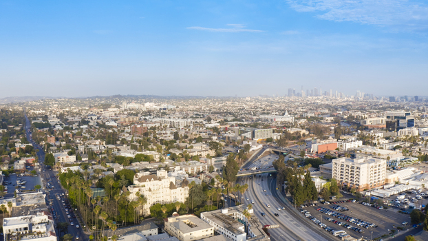 Aerial view of the sprawling urban landscape of Los Angeles featuring residential neighborhoods a busy highway and the distant city skyline in Los Angeles California United States.