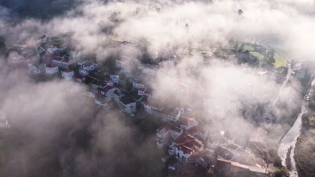 Aerial view of Avo village shrouded in thick morning fog Portugal. Aerial view of Avo village shrouded in thick morning fog Portugal.
