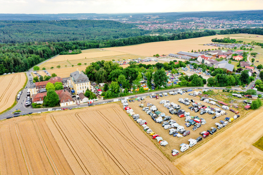 Eggolsheim Germany 09 May 2026 Aerial view of Schloss Jagersburg surrounded by lush trees parking lots filled with vehicles and golden fields. Eggolsheim Germany 09 May 2026 Aerial view of Schloss Jagersburg surrounded by lush trees parking lots filled with vehicles and golden fields.