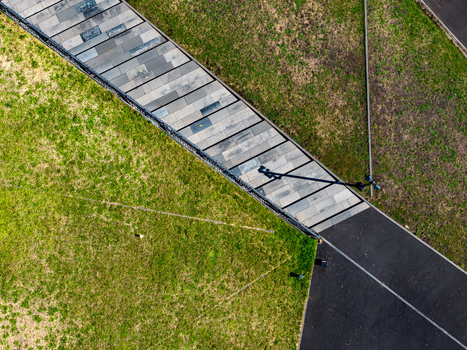 Aerial view of the Katowice International Conference Centre featuring a paved walkway cutting through a green roof with geometric lines and shadows Katowice Wojewodztwo slaskie Poland. Aerial view of the Katowice International Conference Centre featuring a paved walkway cutting through a green roof with geometric lines and shadows Katowice Wojewodztwo slaskie Poland.