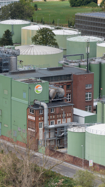 Monheim am Rhein Germany 04 September 2026 Aerial view of UNIFERM GmbH Co. KG industrial facility with large storage tanks brick buildings and industrial piping.