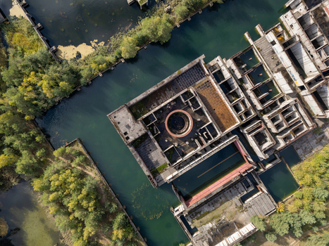Aerial view of the abandoned Zarnowiec Nuclear Power Plant foundations featuring concrete structures and water filled basins surrounded by dense forest in Zarnowiec Poland. Aerial view of the abandoned Zarnowiec Nuclear Power Plant foundations featuring concrete structures and water filled basins surrounded by dense forest in Zarnowiec Poland.
