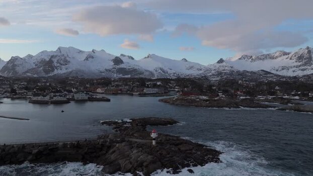 Aerial view of Lofoten lighthouse and snowy mountains Norway.