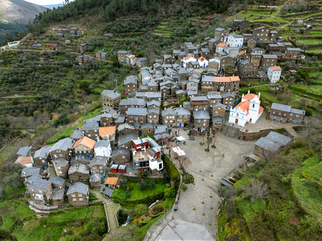 Aerial view of the historic village nestled in the valley with its distinctive schist stone houses and the bright white church standing out Piódão Arganil Portugal. Aerial view of the historic village nestled in the valley with its distinctive schist stone houses and the bright white church standing out Piódão Arganil Portugal.