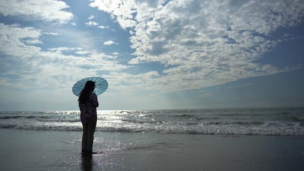 View of a woman with an umbrella on the beach Bangladesh.