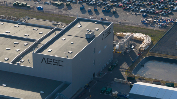 Lambres lez Douai France 07 July 2026 Aerial view of the AESC France battery factory facility with industrial buildings rooftop structures and a large parking lot filled with cars.