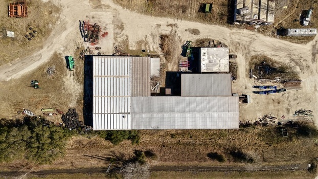 Aerial view of a cluster of industrial buildings with corrugated metal roofs amidst dry sun baked earth Elkton Florida United States. Aerial view of a cluster of industrial buildings with corrugated metal roofs amidst dry sun baked earth Elkton Florida United States.