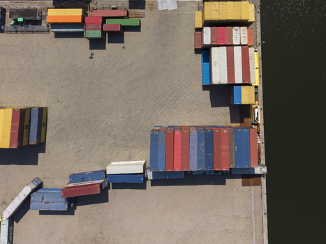 Aerial view of TMA Terminals Lelystad featuring rows of colorful shipping containers stacked on the concrete port area next to the water in Lelystad Flevoland Netherlands. Aerial view of TMA Terminals Lelystad featuring rows of colorful shipping containers stacked on the concrete port area next to the water in Lelystad Flevoland Netherlands.
