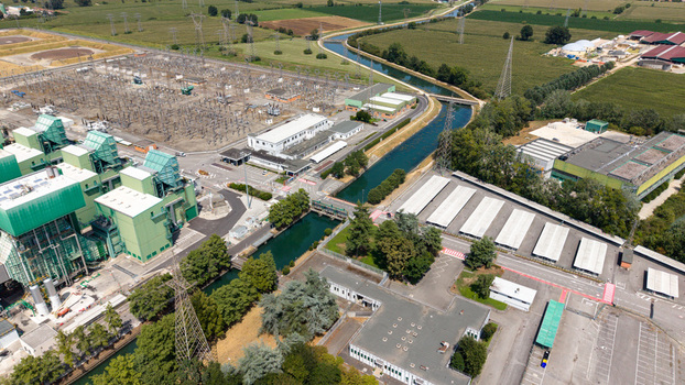 Aerial view of the TTEP Tavazzano thermal power plant and TERNA electrical substation with industrial buildings power lines and a canal in Tavazzano con Villavesco Lombardy Italy.
