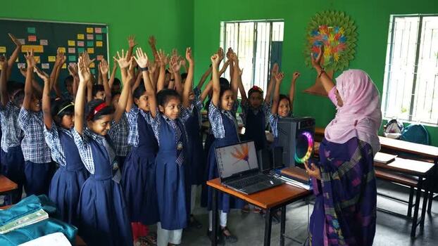 View of students with raised hands in a classroom Bangladesh.