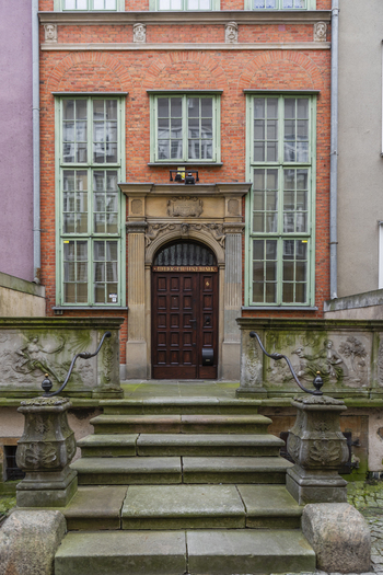 Gdansk Pomeranian Voivodeship Poland 07 September 2026 View of the historic brick building entrance with ornate stone steps mossy balustrades and a dark wooden door. Gdansk Pomeranian Voivodeship Poland 07 September 2026 View of the historic brick building entrance with ornate stone steps mossy balustrades and a dark wooden door.