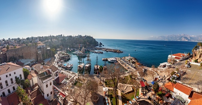View of the historic Kaleici harbor with traditional wooden boats docked along the stone walls under a bright sun in Antalya Antalya Turkey.