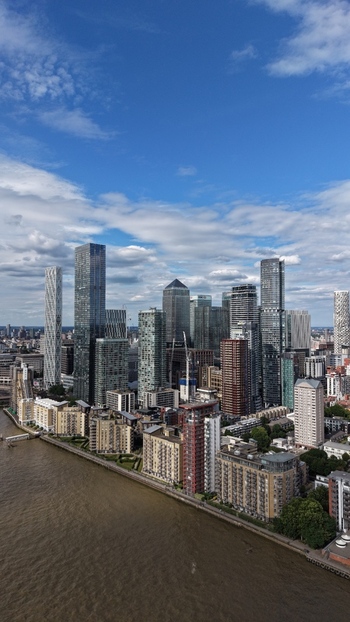 London United Kingdom 16 June 2026 Aerial view of the Canary Wharf financial district skyline with modern skyscrapers the River Thames and residential apartment blocks.