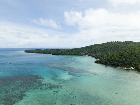 Aerial view of a tranquil coastline where turquoise waters meet lush greenery a tropical paradise unfolds Karimunjawa Central Java Indonesia.