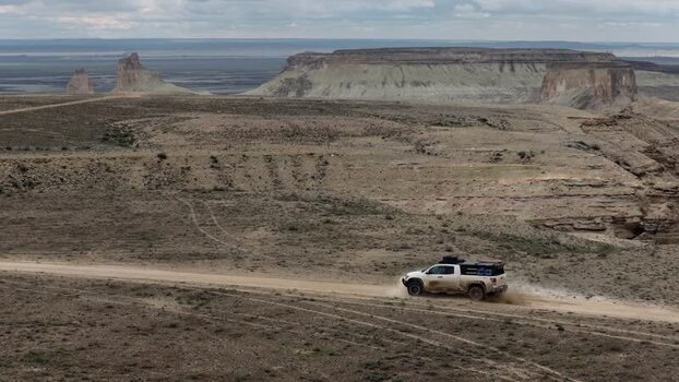 Aerial view of a pickup truck driving through the Bozjyra canyon Kazakhstan. Aerial view of a pickup truck driving through the Bozjyra canyon Kazakhstan.