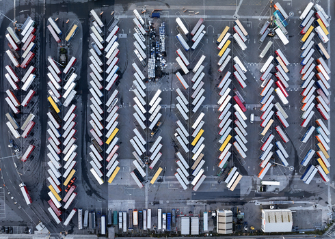 Aerial view of Dublin Port featuring organized rows of parked semi trailers and shipping containers in a large logistics yard in Dublin County Dublin Ireland. Aerial view of Dublin Port featuring organized rows of parked semi trailers and shipping containers in a large logistics yard in Dublin County Dublin Ireland.
