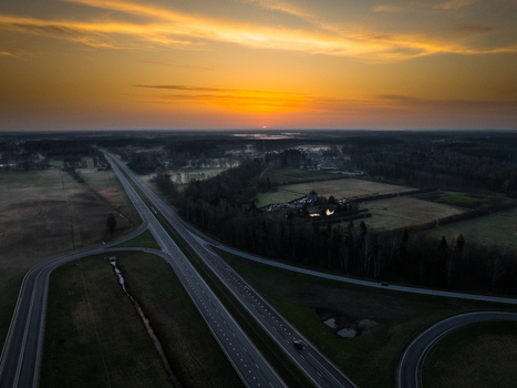 Aerial view of the highway intersection between the A5 and A8 roads at sunset with golden light over the rural landscape and fields in Olaine parish Olaine Municipality Latvia. Aerial view of the highway intersection between the A5 and A8 roads at sunset with golden light over the rural landscape and fields in Olaine parish Olaine Municipality Latvia.