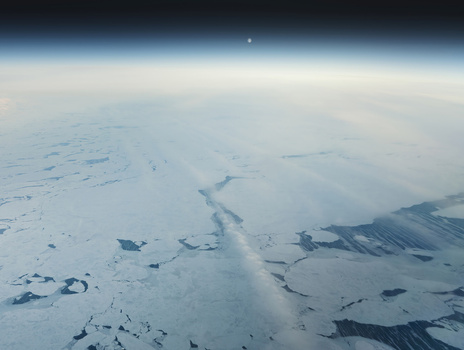 Aerial view of icy expanses reflect the ethereal glow of the horizon a stark contrast against the deep blue of the sky Narsarsuaq Greenland.