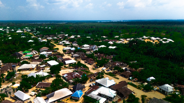 Aerial view of the village of Abua featuring residential houses lush green vegetation and dirt paths in Abua Rivers Nigeria. Aerial view of the village of Abua featuring residential houses lush green vegetation and dirt paths in Abua Rivers Nigeria.