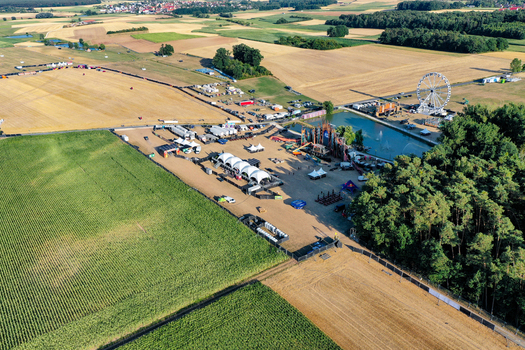 Herzogenaurach Germany 22 July 2022 Aerial view of Open Beatz Festival with a ferris wheel stages and tents surrounded by agricultural fields and forests. Herzogenaurach Germany 22 July 2022 Aerial view of Open Beatz Festival with a ferris wheel stages and tents surrounded by agricultural fields and forests.