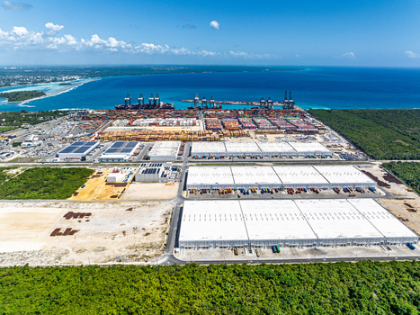 Aerial view of DP World Dominicana port facility featuring shipping containers cranes and large warehouses along the coastline in Boca Chica Santo Domingo Dominican Republic. Aerial view of DP World Dominicana port facility featuring shipping containers cranes and large warehouses along the coastline in Boca Chica Santo Domingo Dominican Republic.